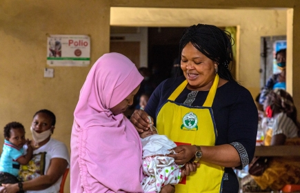 La Rotarienne & responsable de la vaccination à Lagos, Bola Orefejo (à droite), vaccine un enfant. Image : Rotary International